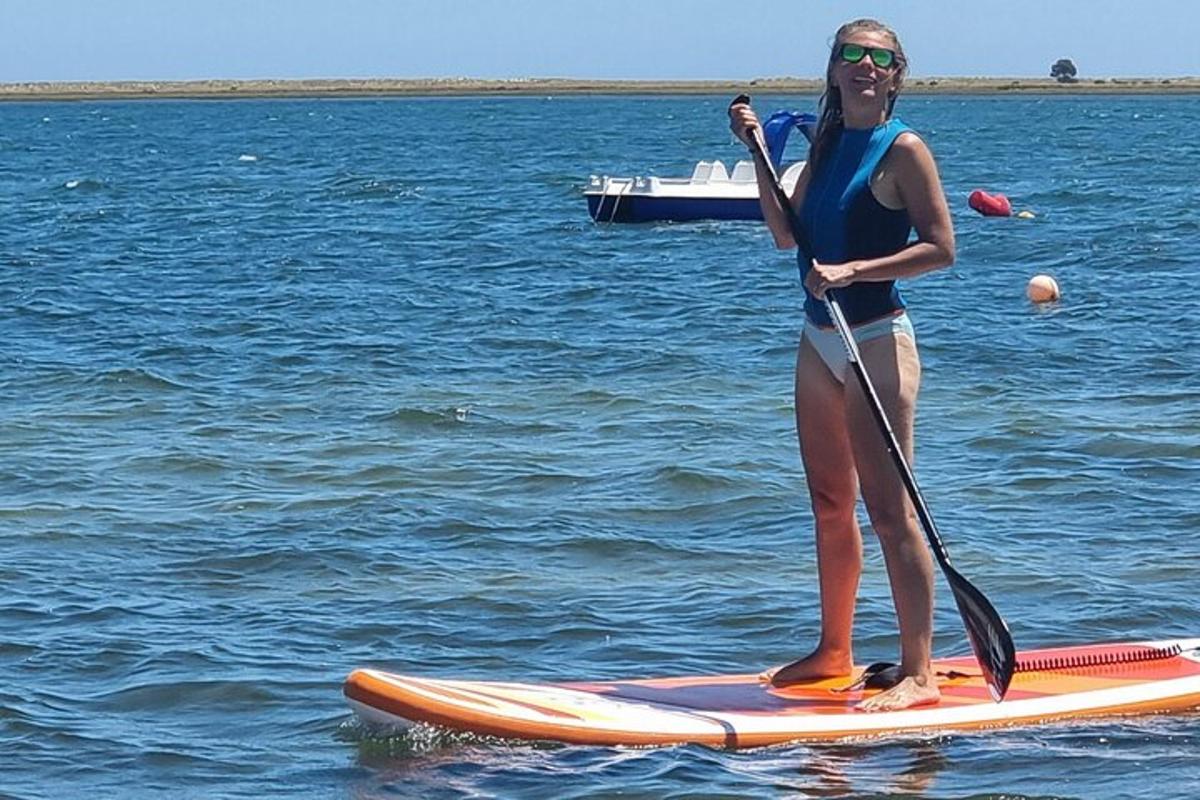 žena stojící na paddleboardu ve vodě
