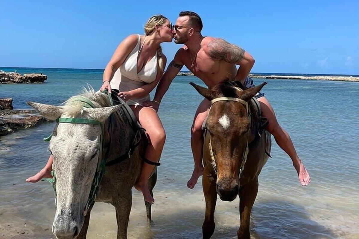 moški in ženska jahata konja na plaži