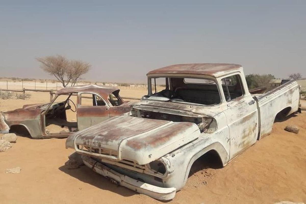 two old trucks are parked in the desert