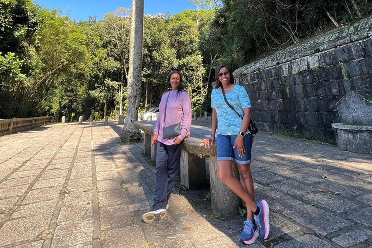 deux femmes debout à côté d'un banc de pierre