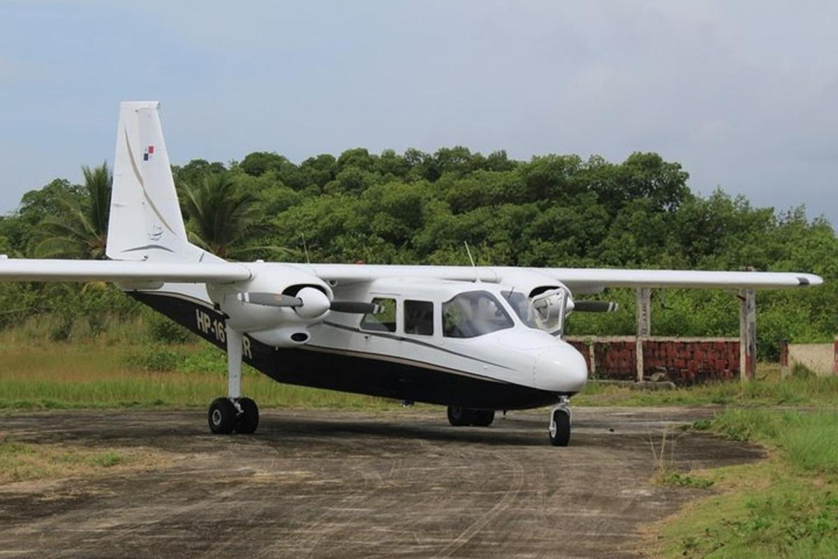 Un pequeño avión blanco estacionado en un camino de tierra.