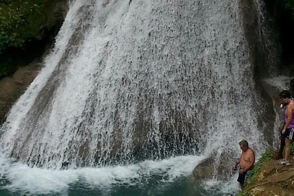 Dos hombres de pie frente a una cascada