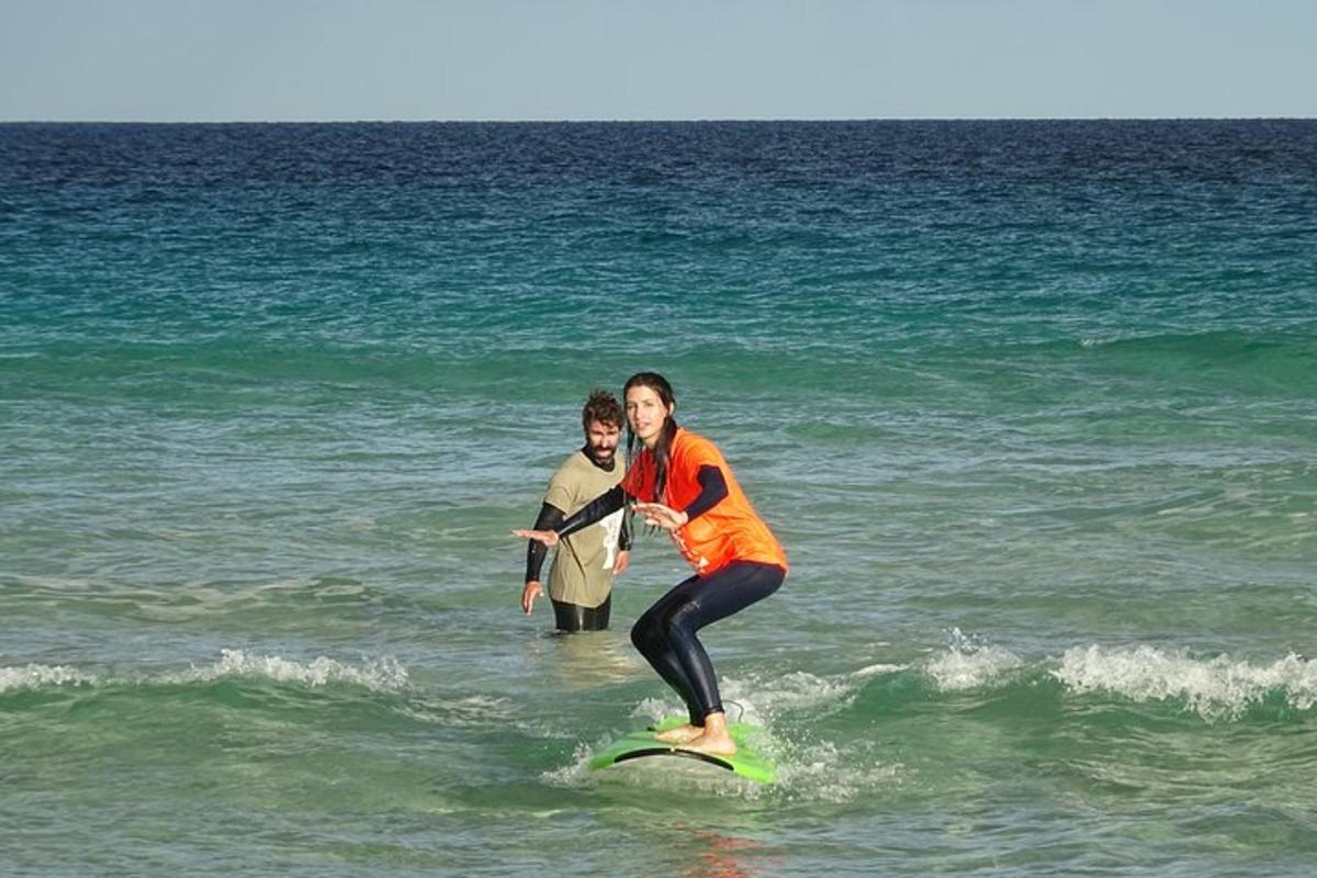 to personer står på et surfbræt i havet