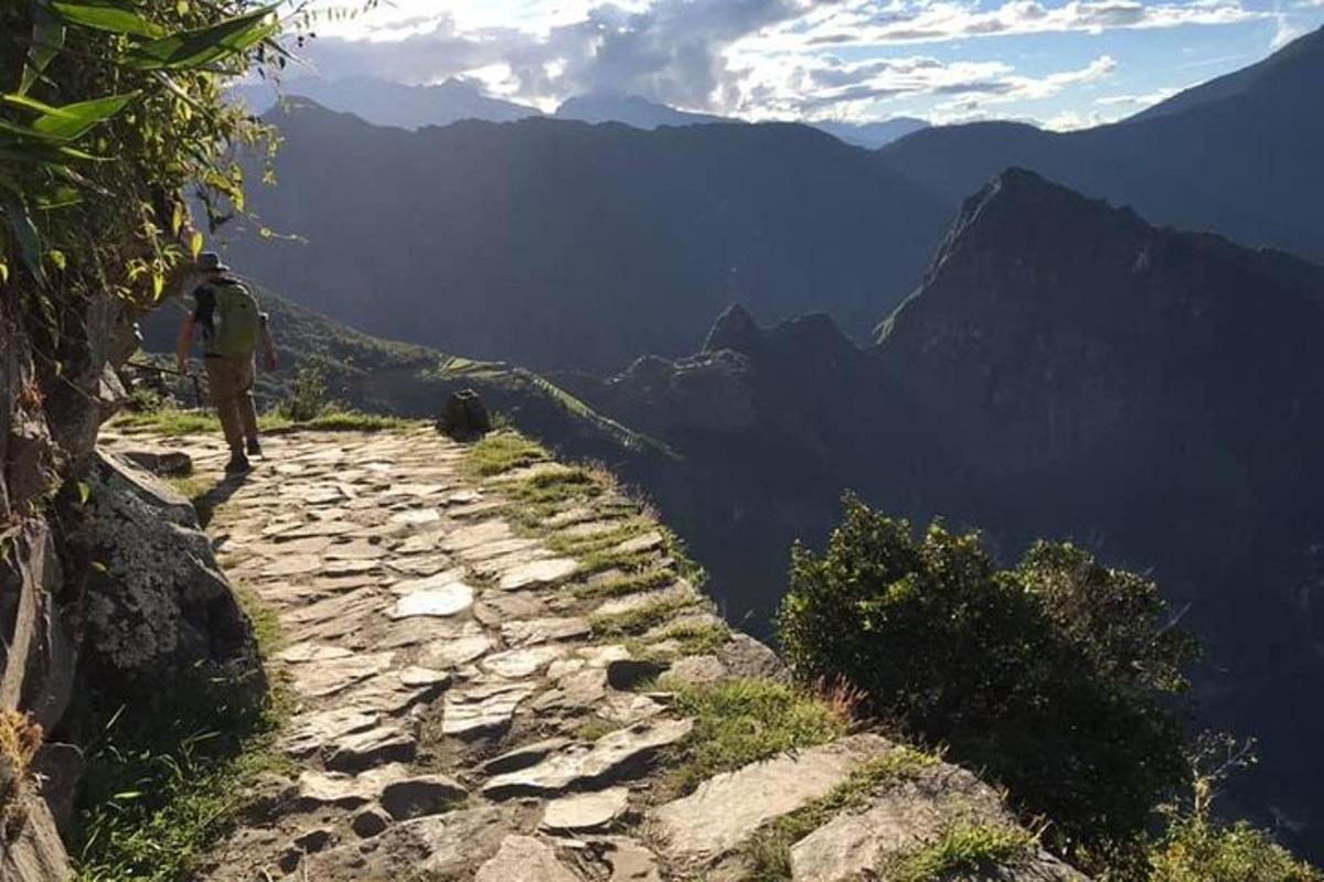 a person walking down a path on a mountain