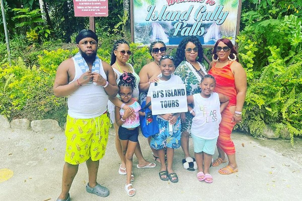 a group of people posing for a picture with a sign
