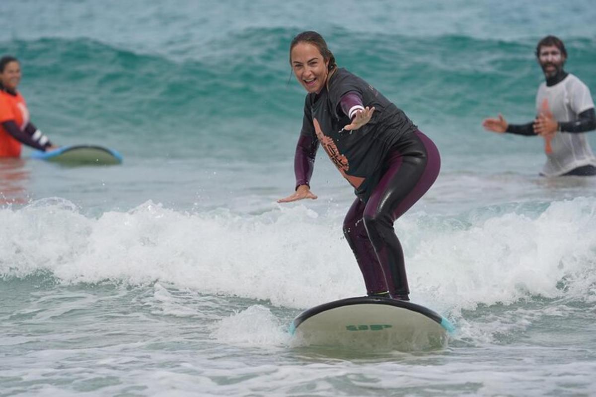 una dona cavalcant una onada sobre una taula de surf a l'oceà