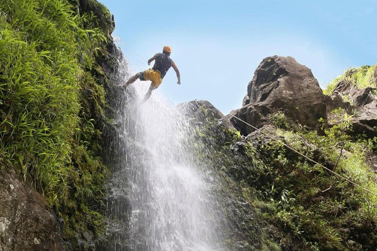 seorang lelaki sedang melompat dari air terjun