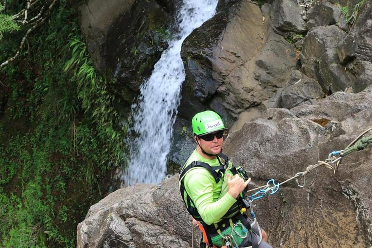 un uomo su una roccia davanti a una cascata