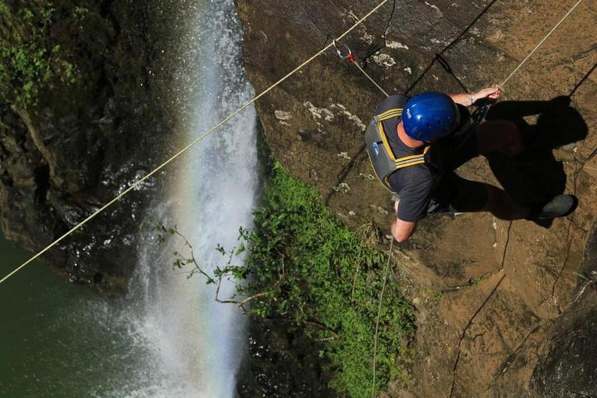 maður stendur á steini við foss