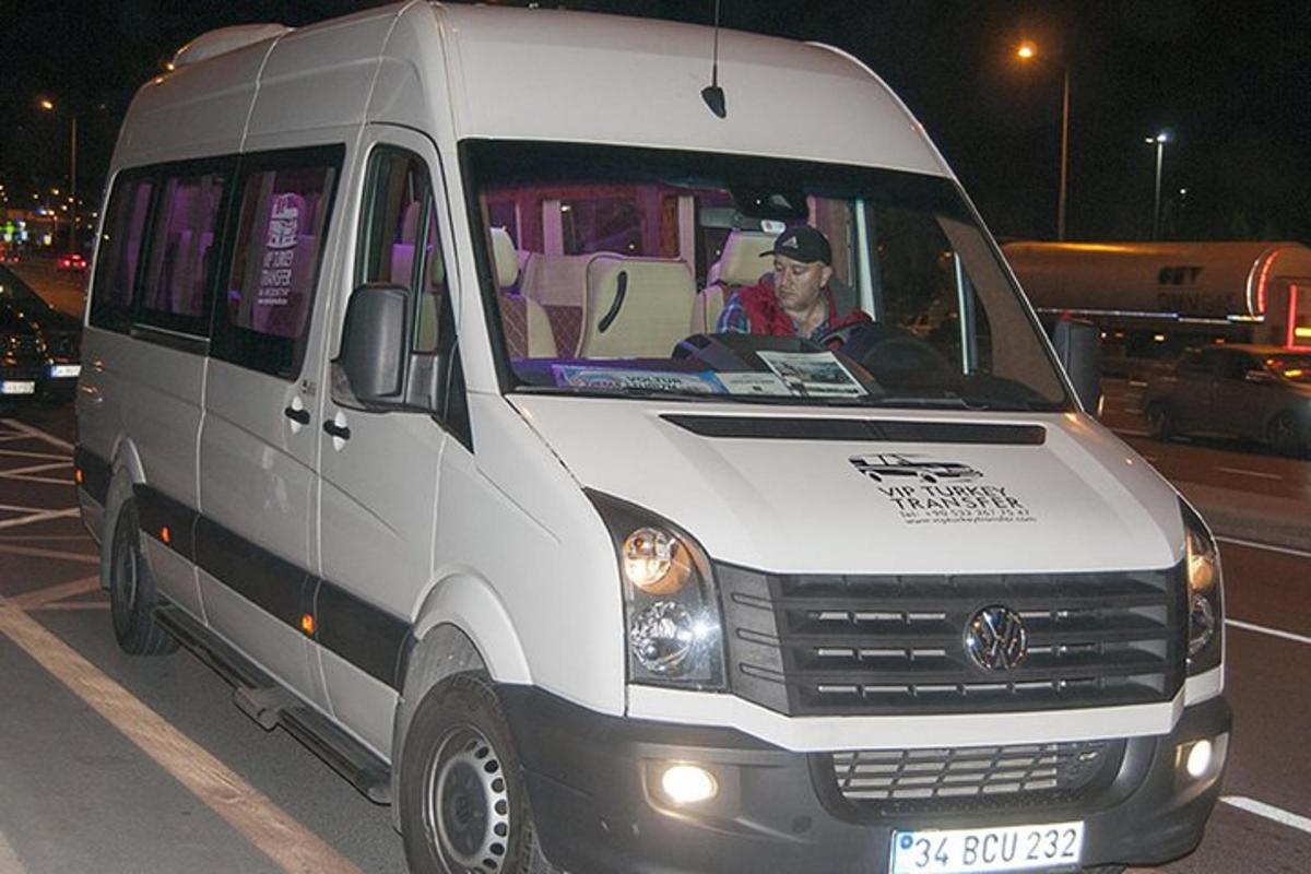 moški, ki sedi spredaj v belem kombiju