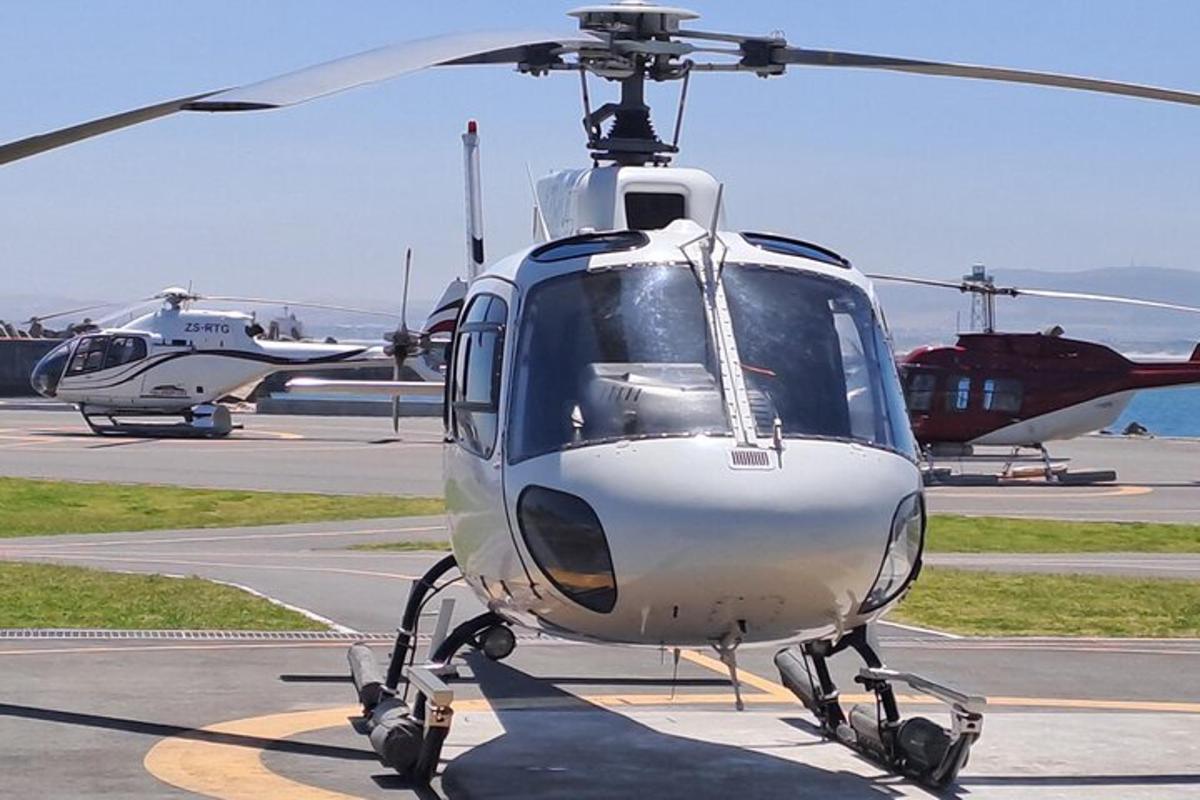 un elicopter alb este parcat pe o pistă
