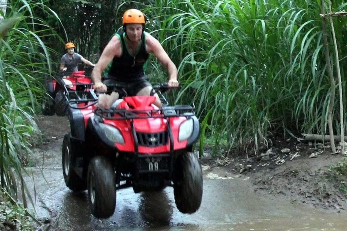 un uomo che guida un quad nel fango