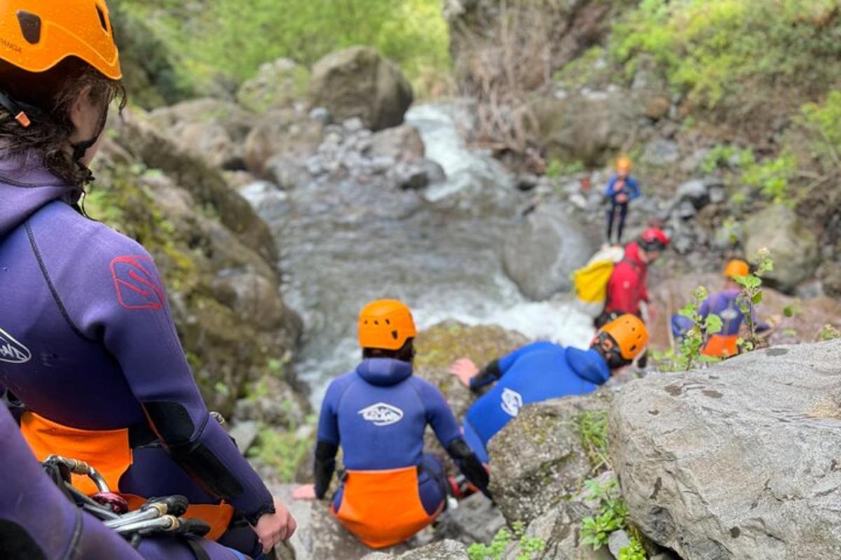 a group of people sitting on rocks near a river