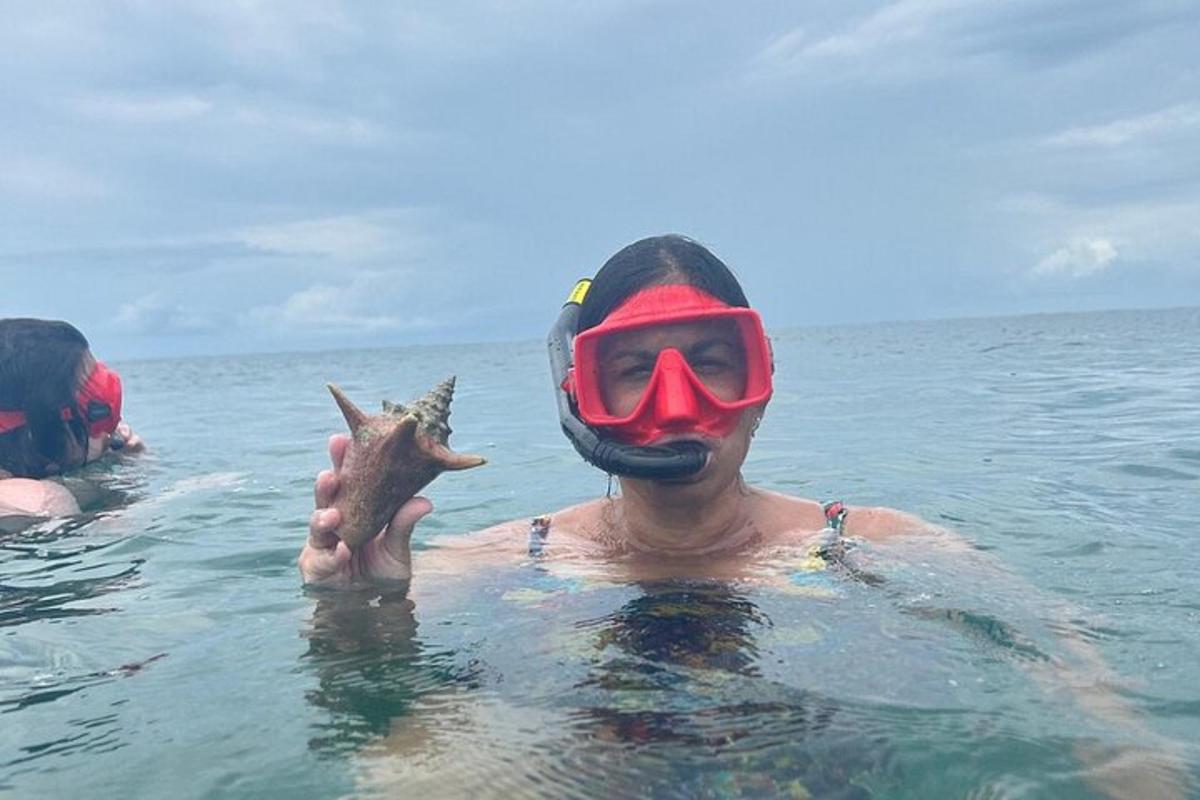 un uomo in acqua con una maschera e un pesce