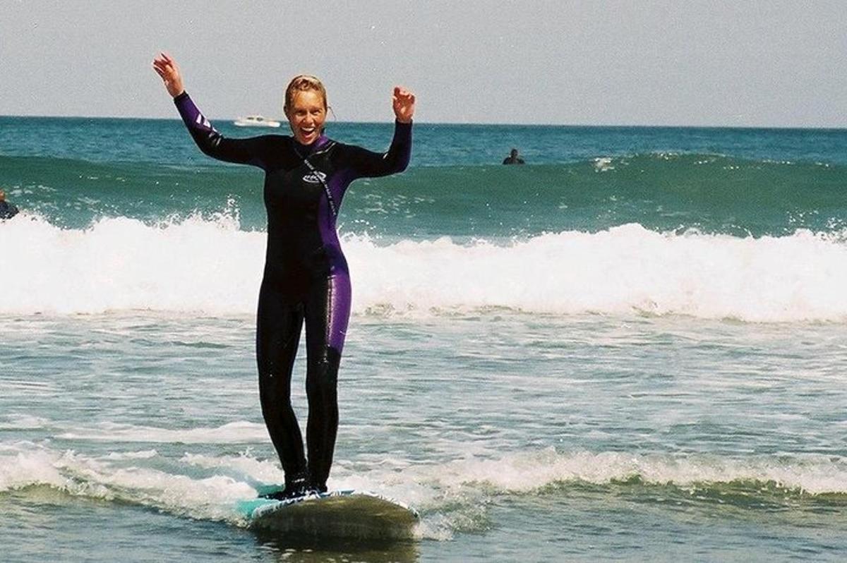 uma mulher em pé em uma prancha de surfe no oceano