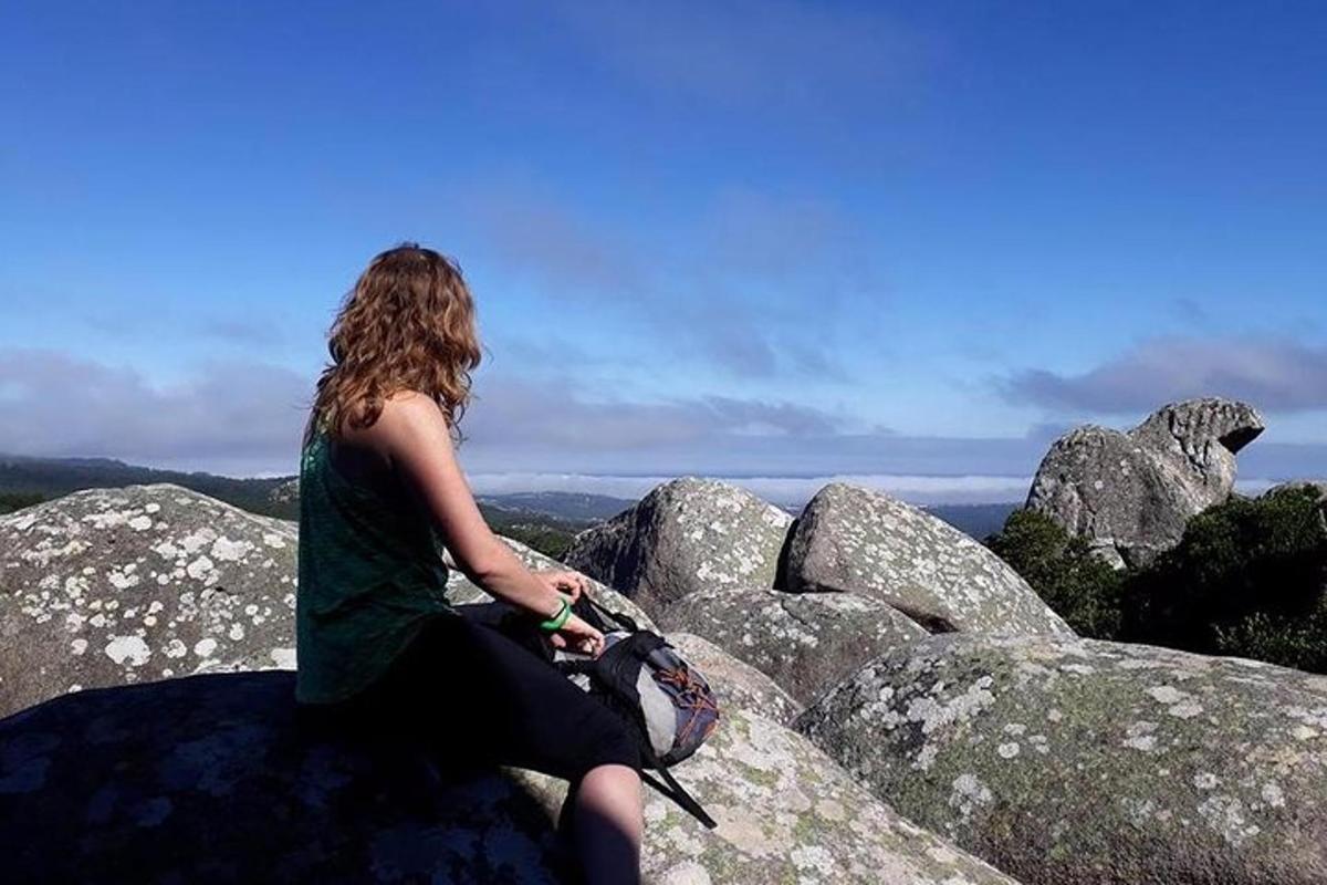 žena sedící na vrcholu skály