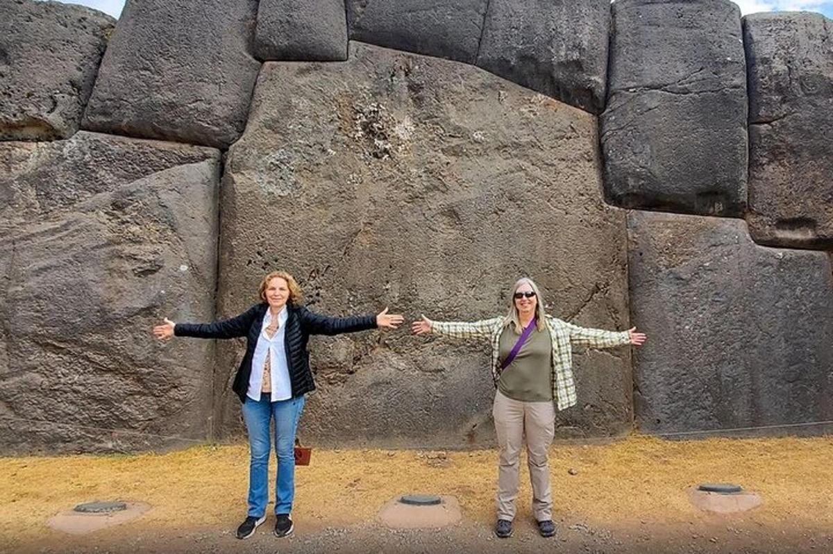 due donne in piedi davanti a una grande roccia