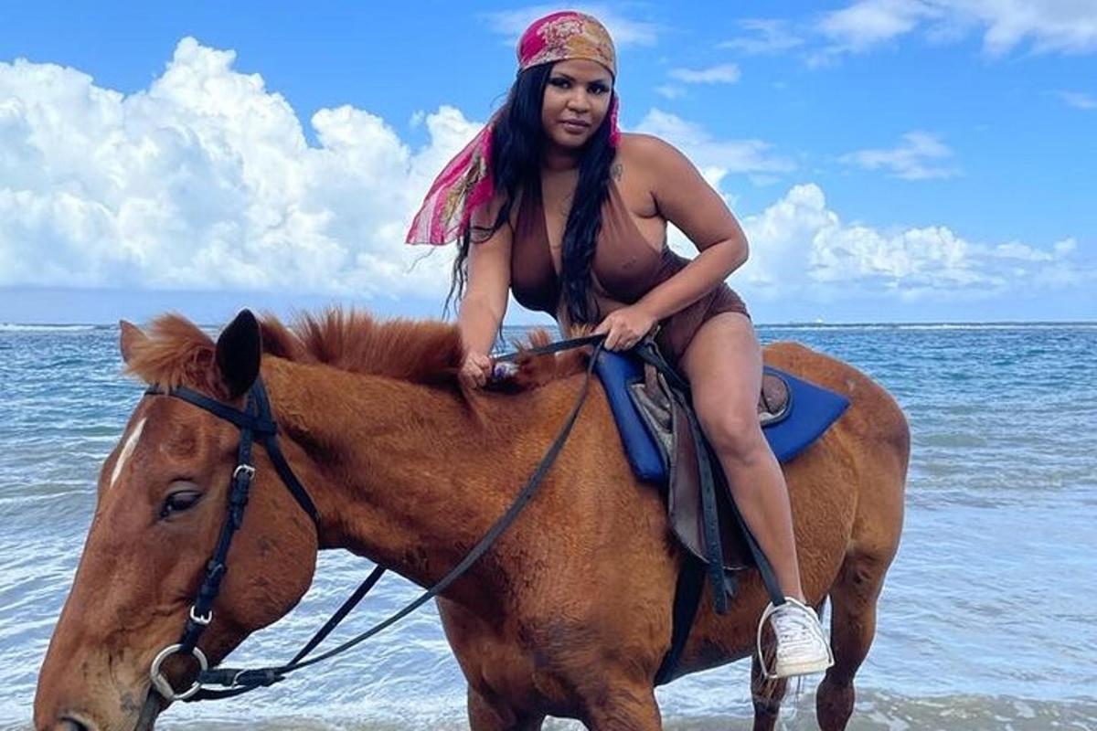 una mujer en bikini montando a caballo en la playa
