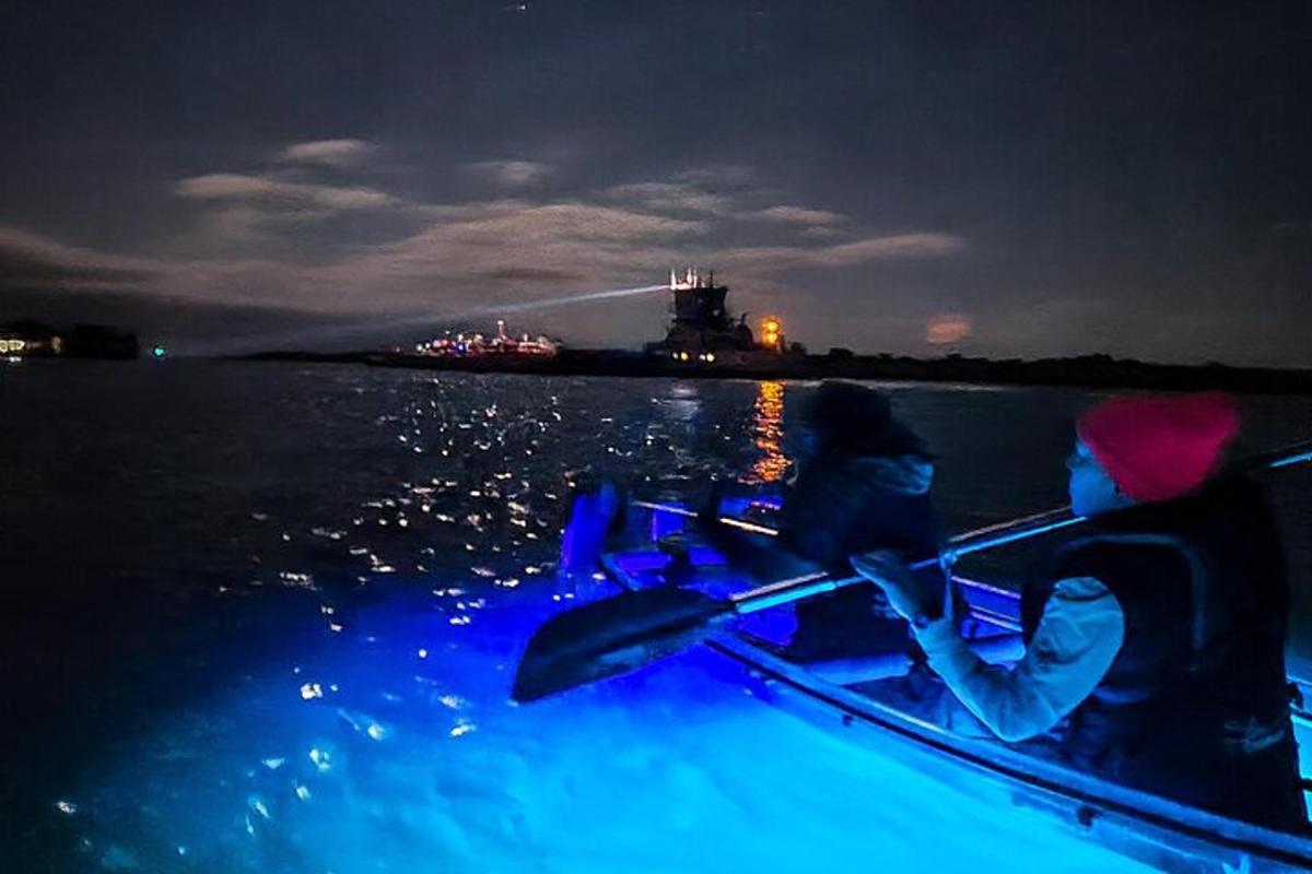 zwei Personen in einem Boot auf dem Wasser in der Nacht