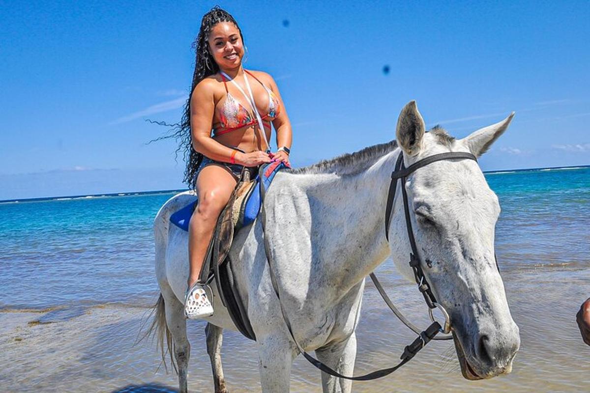 una donna in bikini a cavallo sulla spiaggia