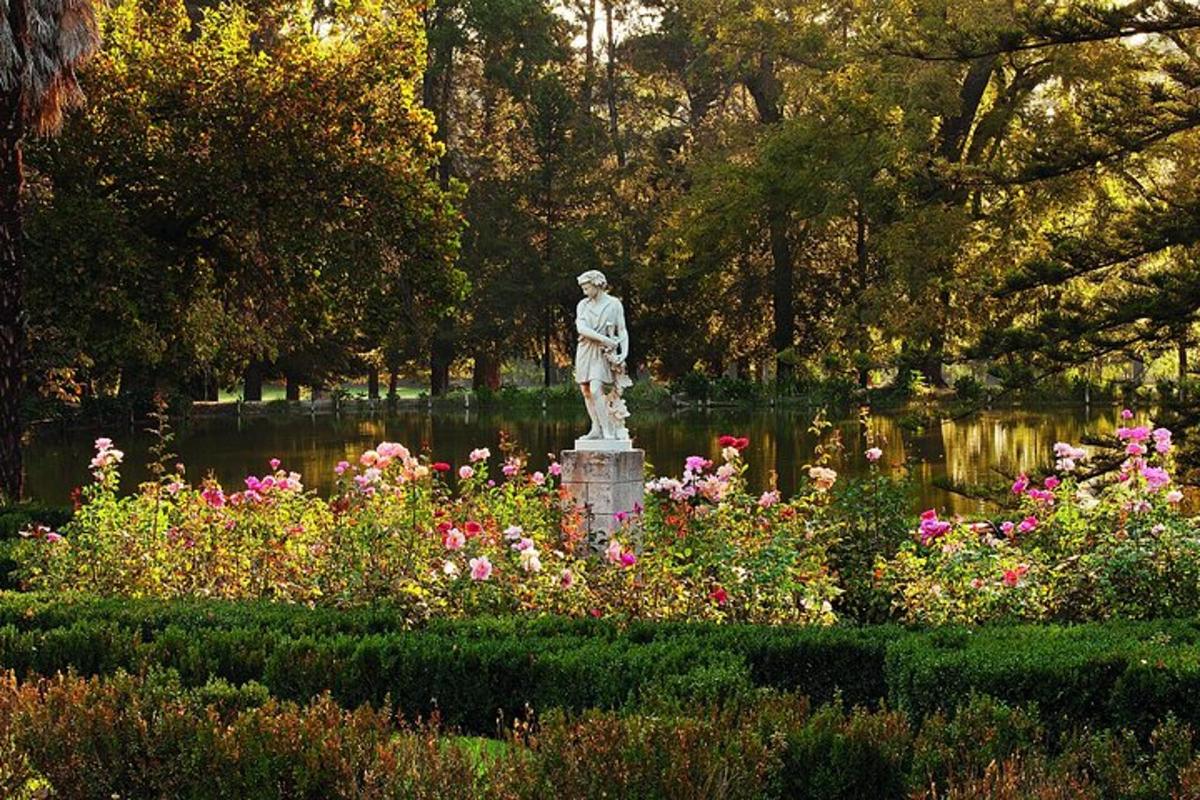 a statue in the middle of a garden with flowers
