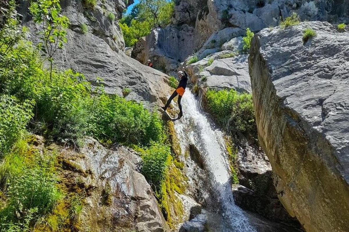 una persona parada sobre una roca junto a una cascada