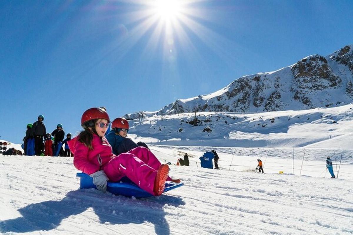 Una niña sentada en la nieve en una pista de esquí