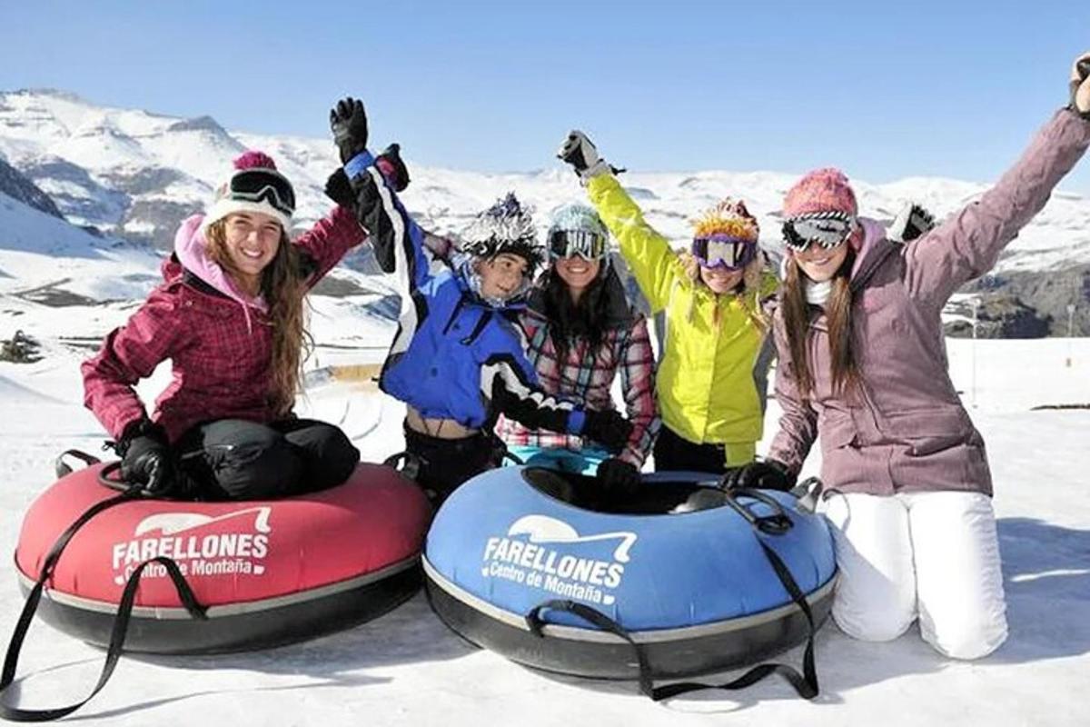 Un grupo de personas sentadas en flotadores de nieve en la nieve.