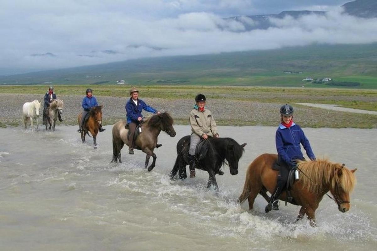 水の中を馬に乗って進む人々のグループ