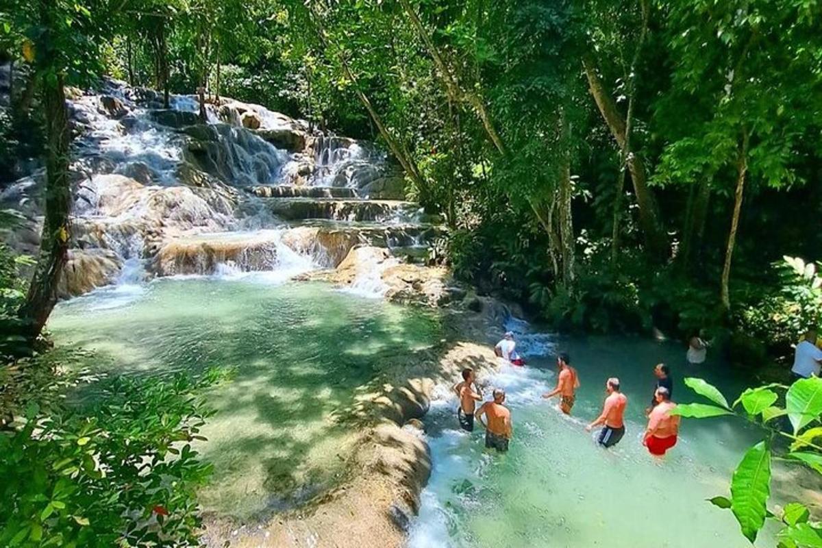 un gruppo di persone in piedi nell'acqua vicino a una cascata