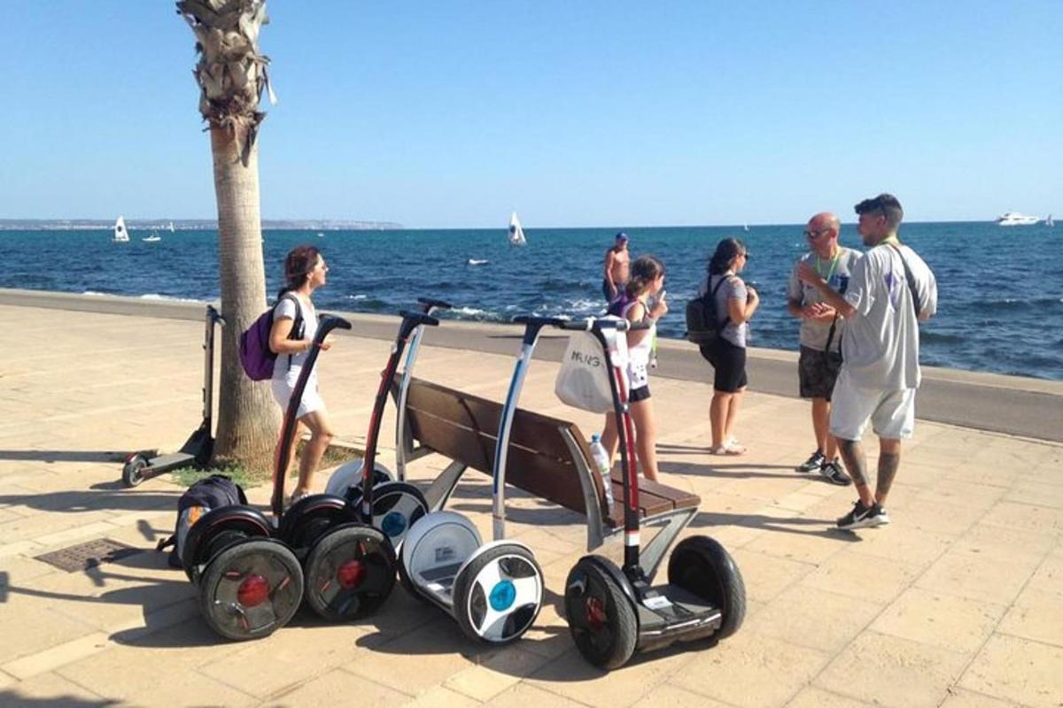 un gruppo di persone in piedi vicino all'oceano con un passeggino