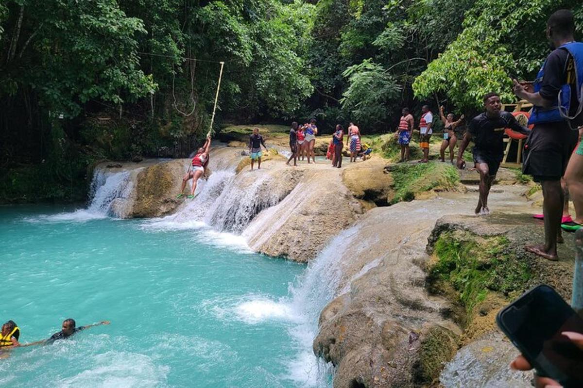 un gruppo di persone in un fiume con una cascata