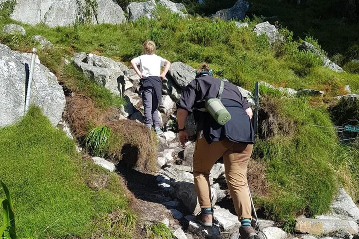 a couple of people walking down a rocky trail