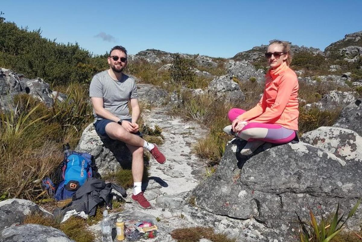 tveir menn sitja á klettum á fjalli