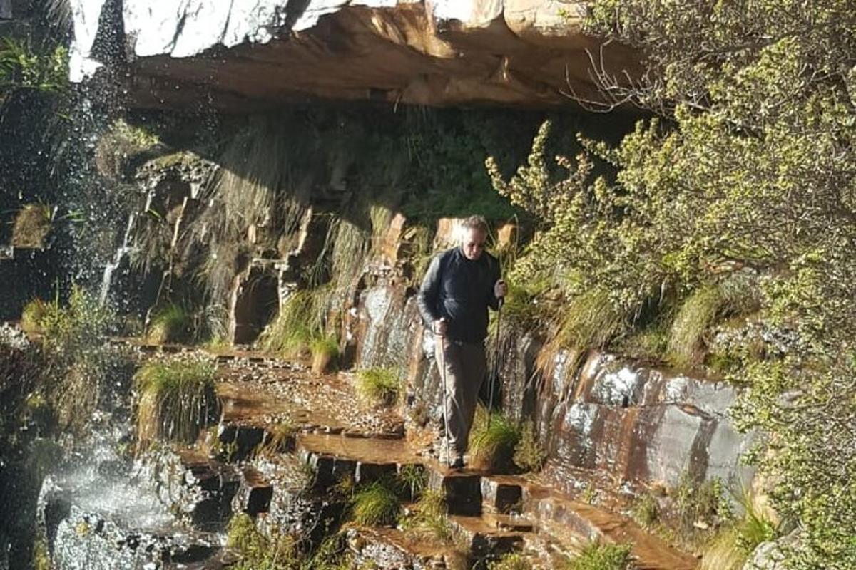 maður gengur á stíg fyrir framan foss