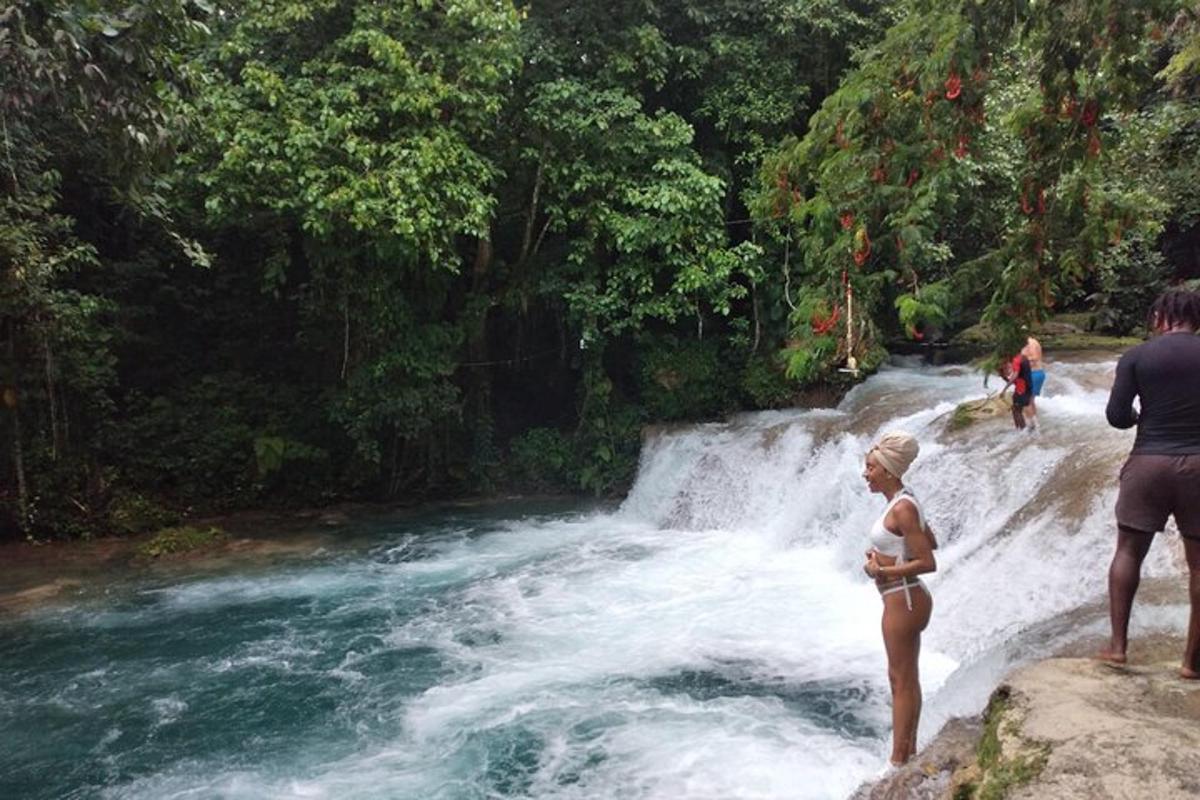 una donna in bikini in piedi davanti a una cascata