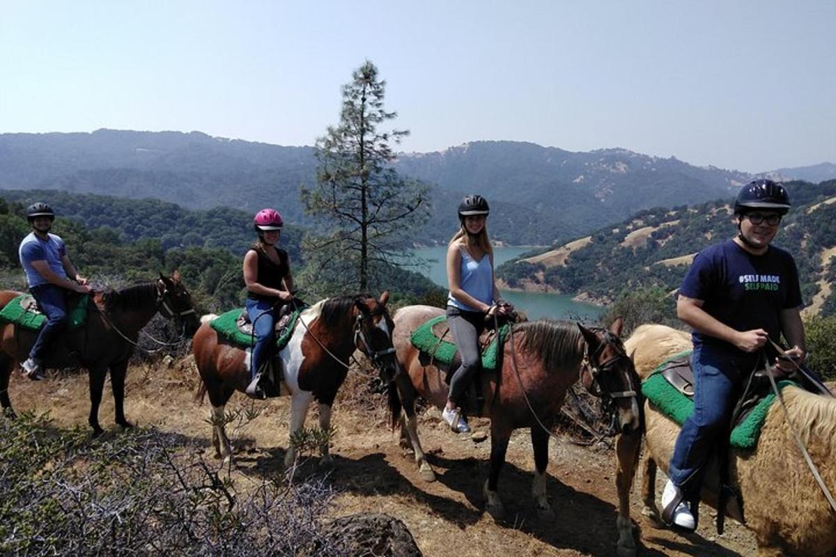 a group of people riding horses on a hill