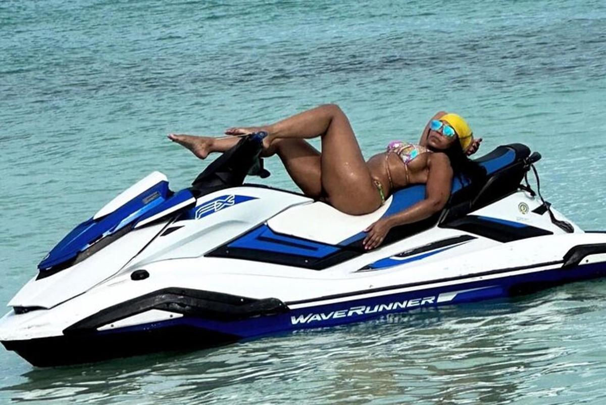 una dona estirada en una moto aquàtica a l'aigua
