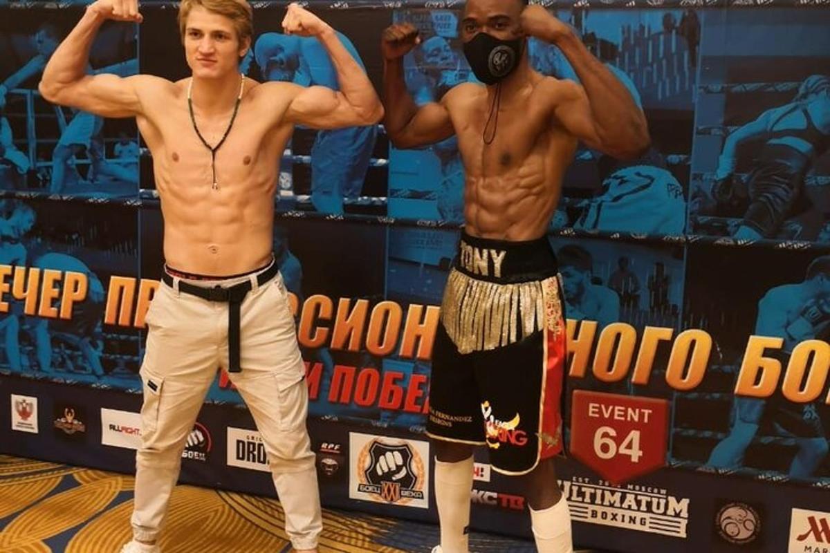Dos hombres están de pie en un ring de boxeo.