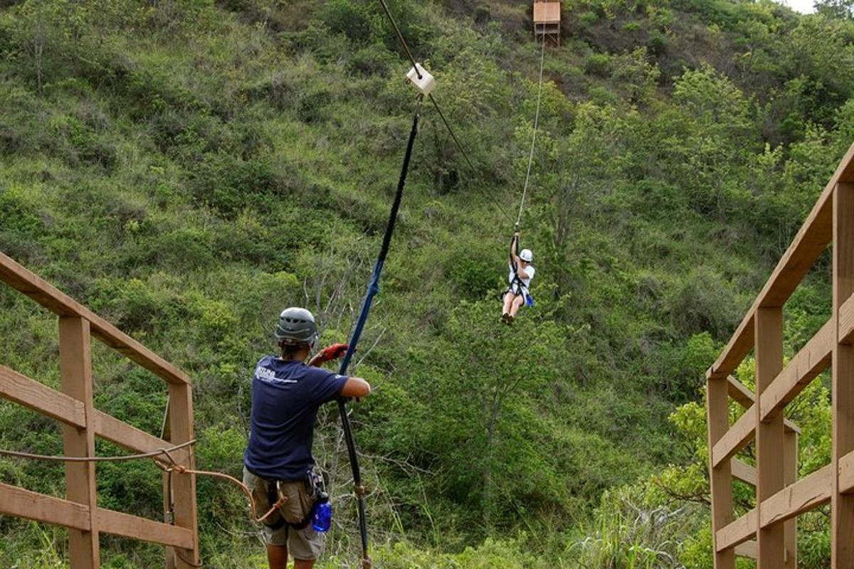 muž na zipline s dvoma ľuďmi na kopci