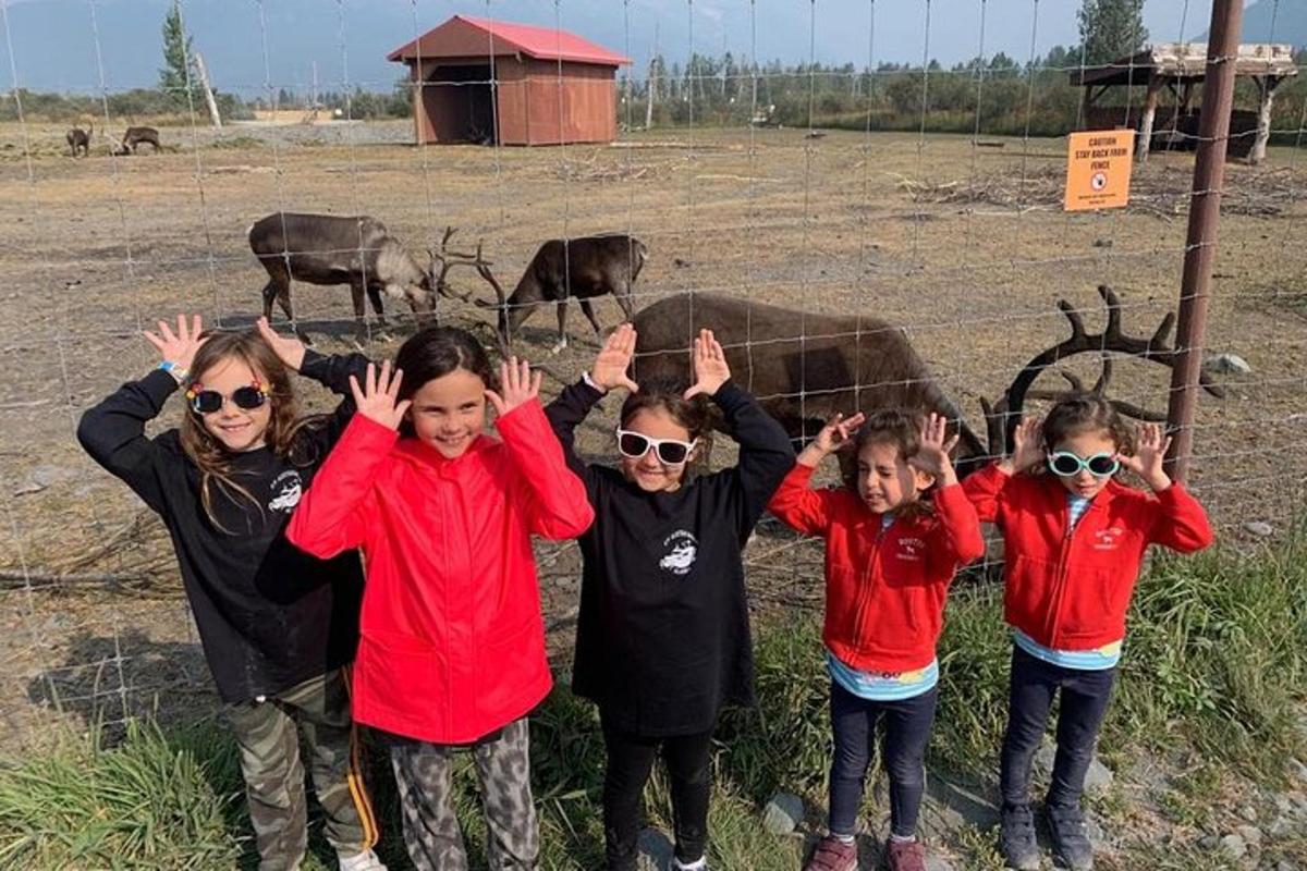 група деце која стоје на пољу са подигнутим рукама