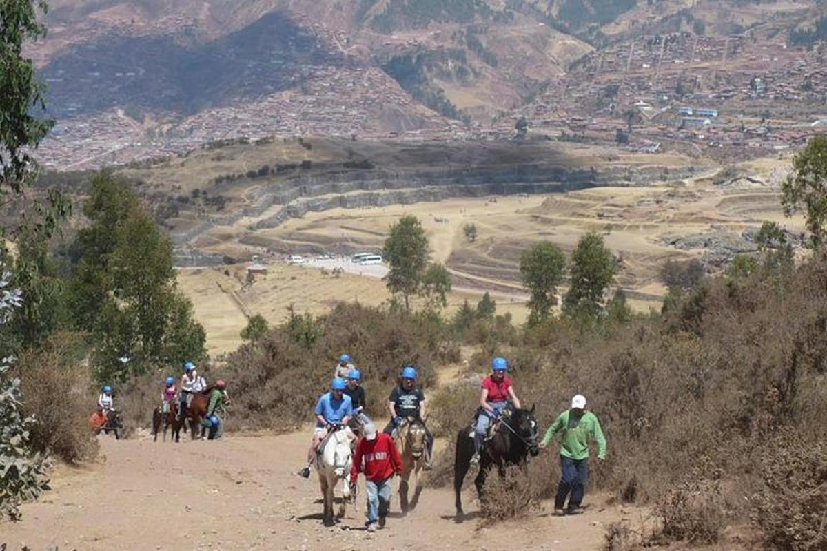 un grup de persones muntant a cavall per un camí de terra