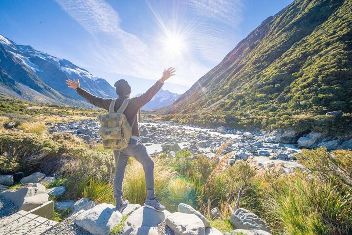 moški, ki stoji na skali in gleda na gorsko dolino