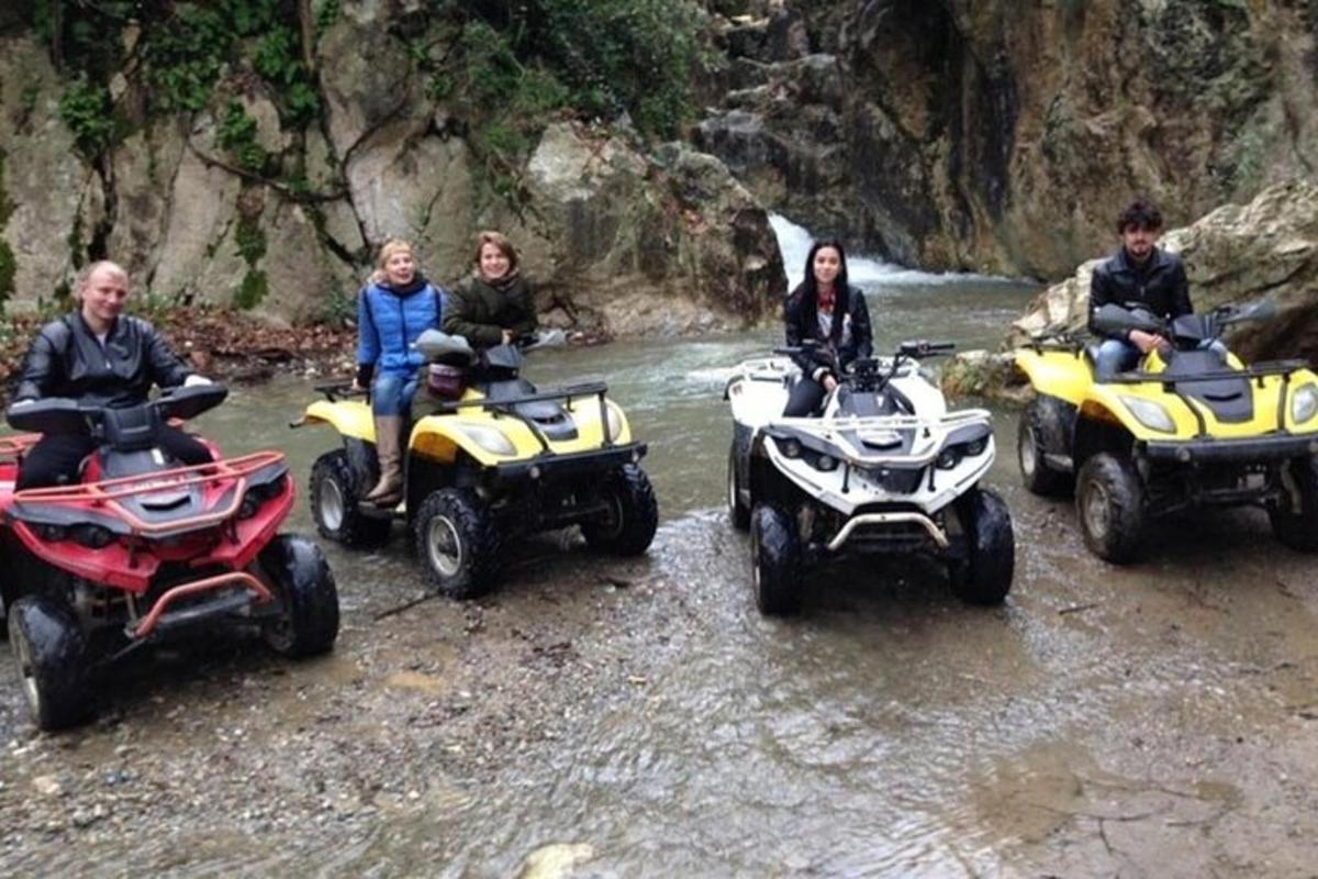 sekumpulan orang duduk di atas atv di sungai