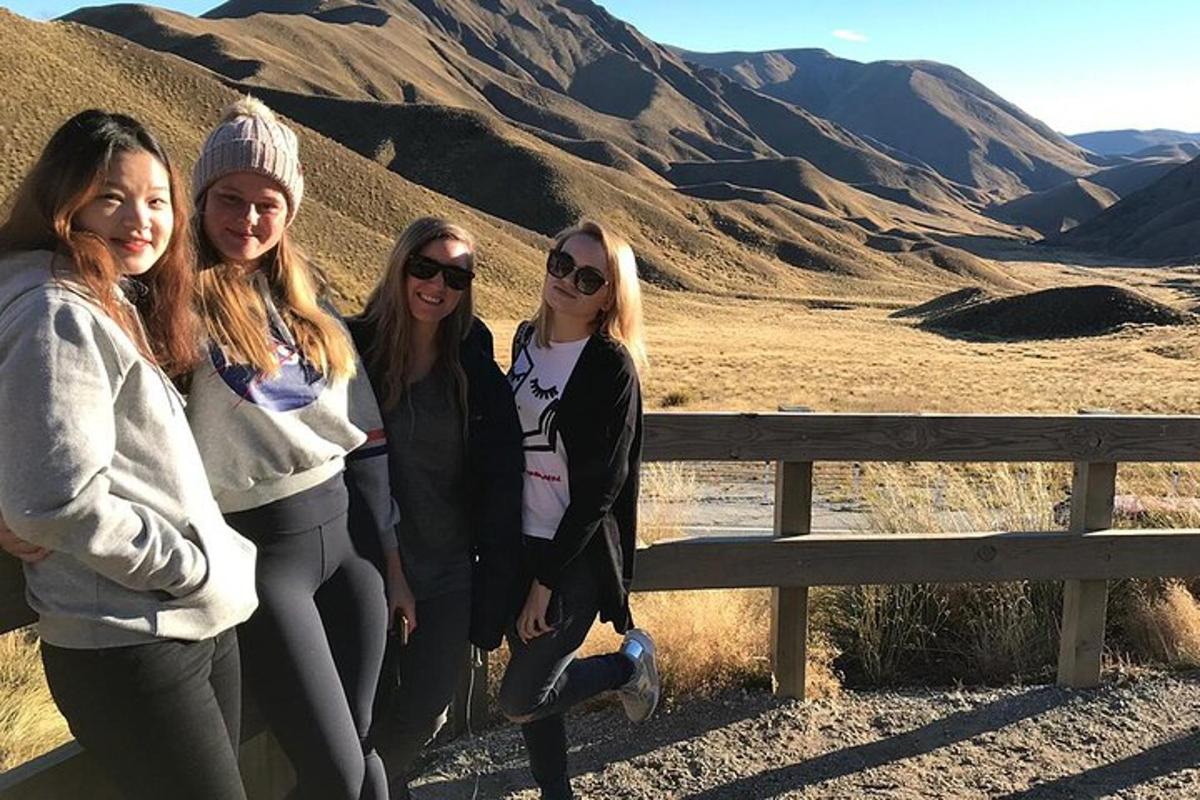 quattro ragazze in piedi accanto a una recinzione in montagna