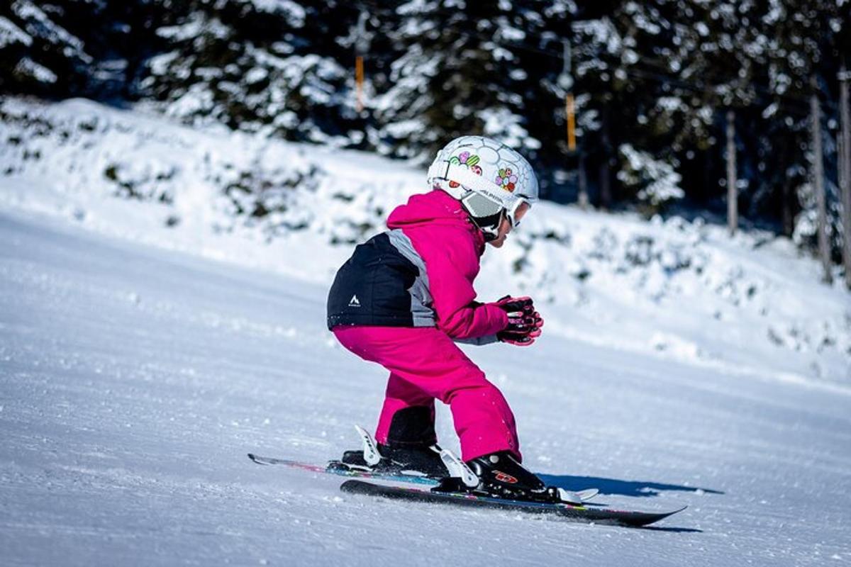 a young child is skiing down a snow covered slope