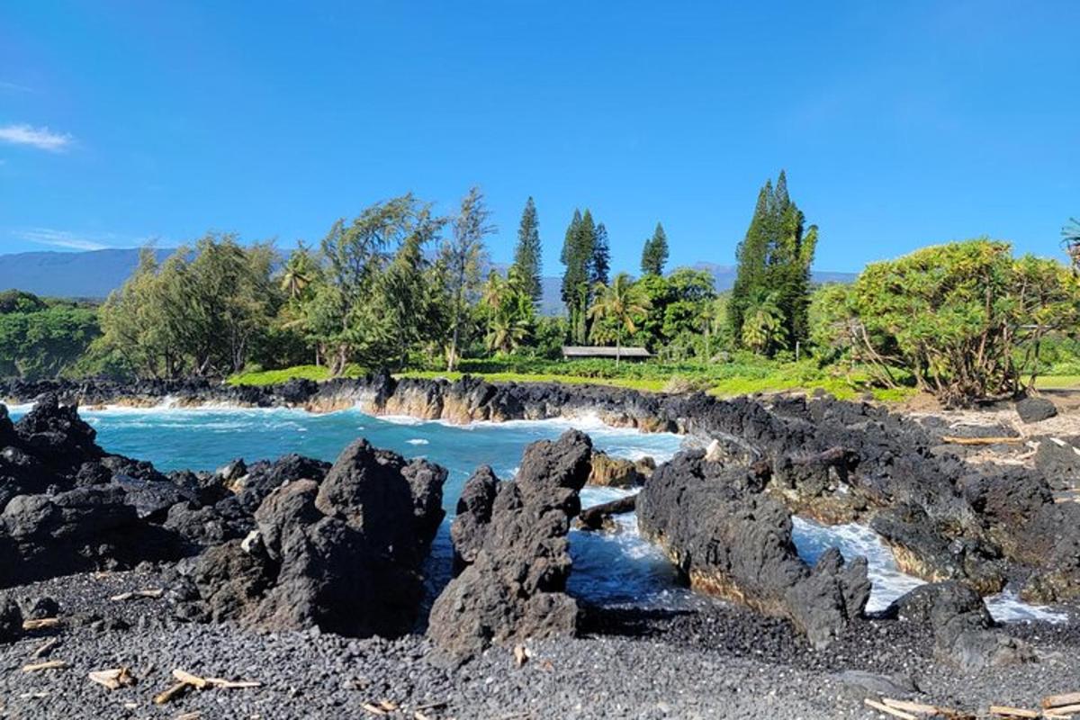 a rock bridge over the water on a beach