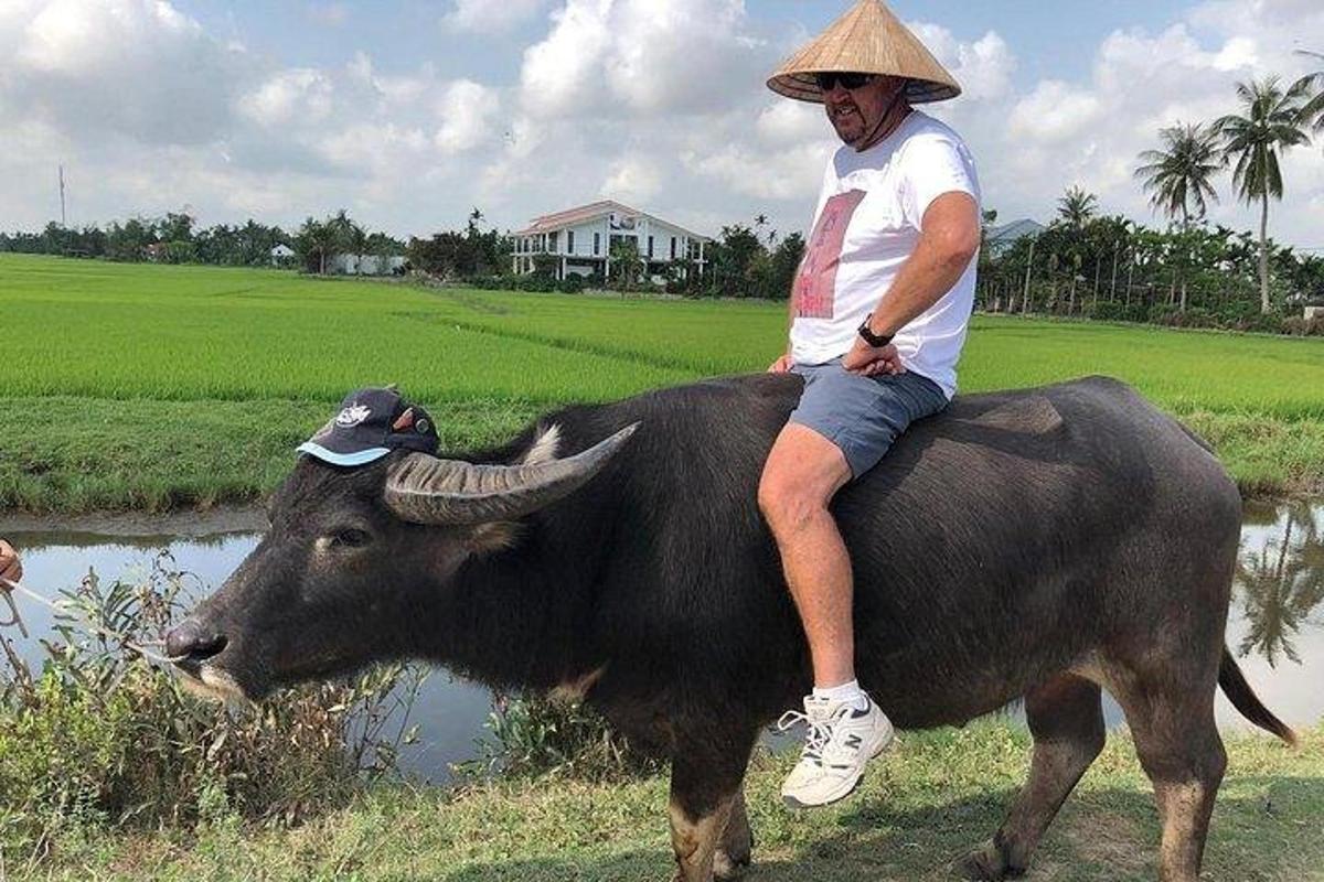 muž sedící na hřbetě býka