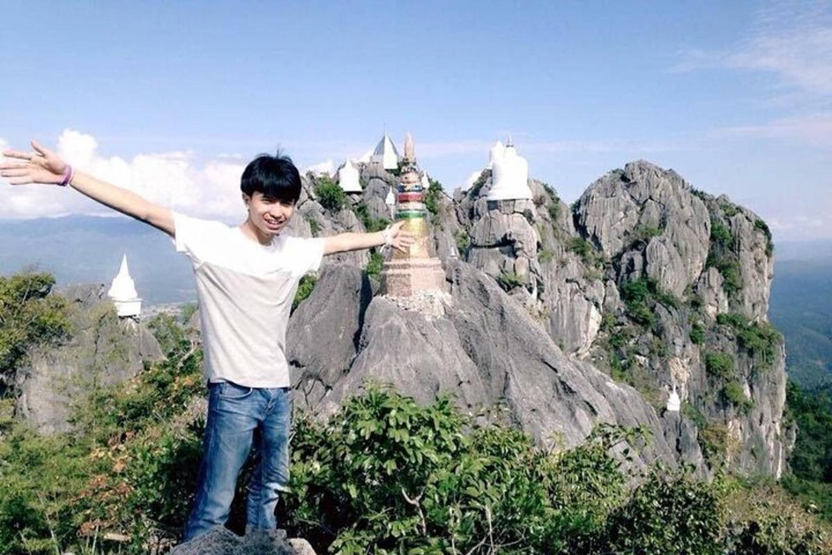 un giovane in piedi sulla cima di una montagna