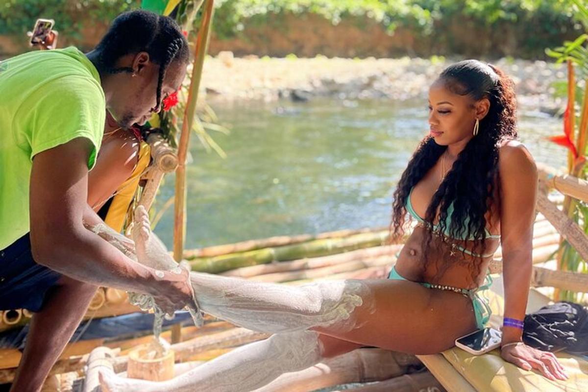 Un hombre y una mujer en bikini sentados junto a un río